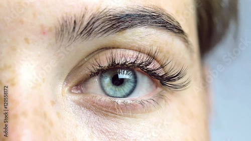 Eye of the girl close-up, woman opening her blue eye