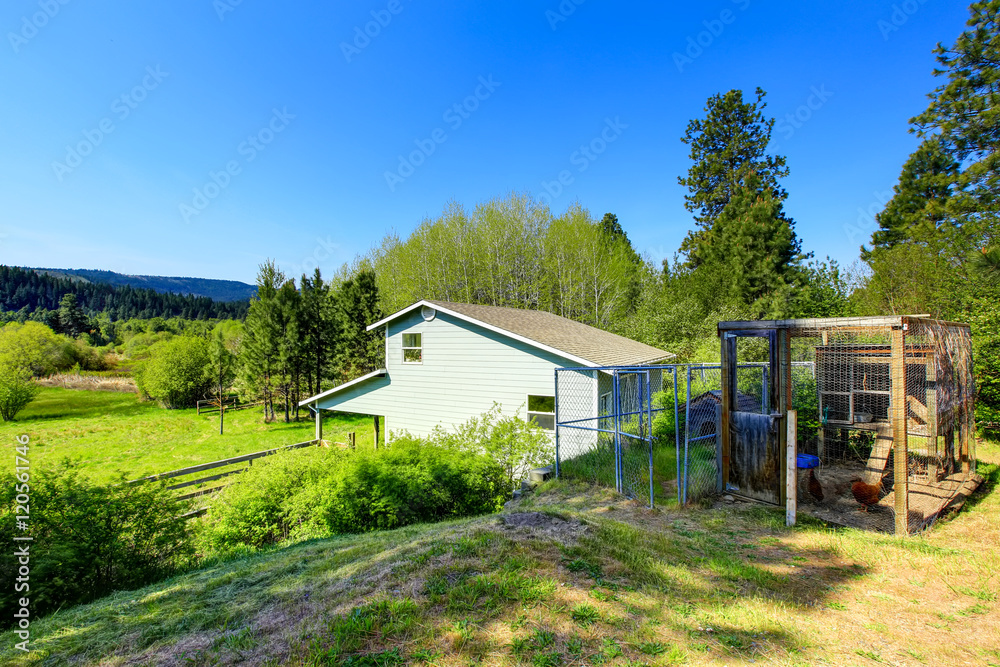 Blue country house backyard view with two metal cages
