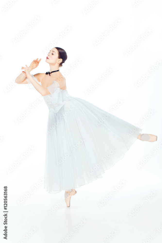 Ballerina in white dress posing on pointe shoes, studio background. Ballerina in white dress posing on pointe shoes, studio background.