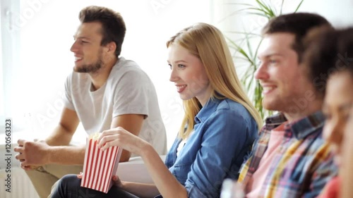 friends with popcorn and beer watching tv at home photo