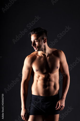 Sexy and expressive shirtless male model flirting against black © alimyakubov