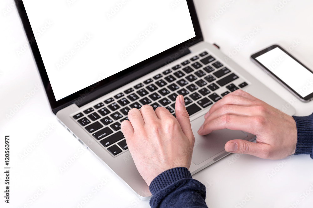 Unrecognizable man using a modern portable computer on an white table
Unrecognizable man using a modern portable computer on an white table