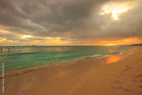Twilight at Waikiki beach in Oahu. Waikiki beach is a beautiful place to enjoy the sunset over the ocean. Waikiki in South Shore  is the neighborhood of Honolulu and the most popular beach of Hawai.