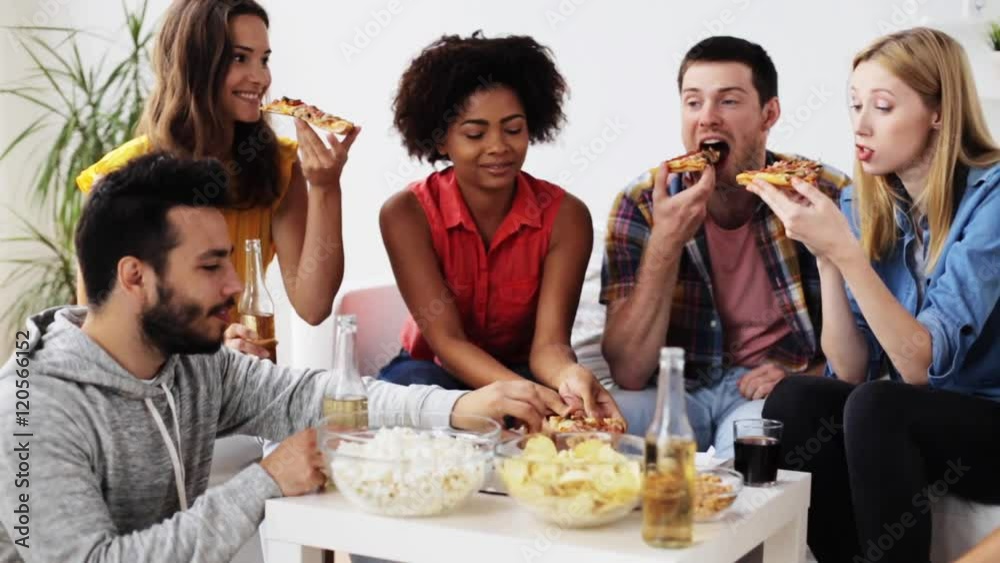 happy friends with drinks eating pizza at home