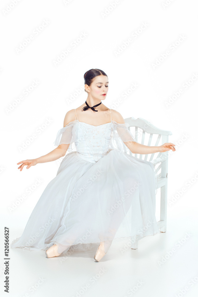 Ballerina in white dress sitting, studio background. Ballerina in white dress sitting, studio background.