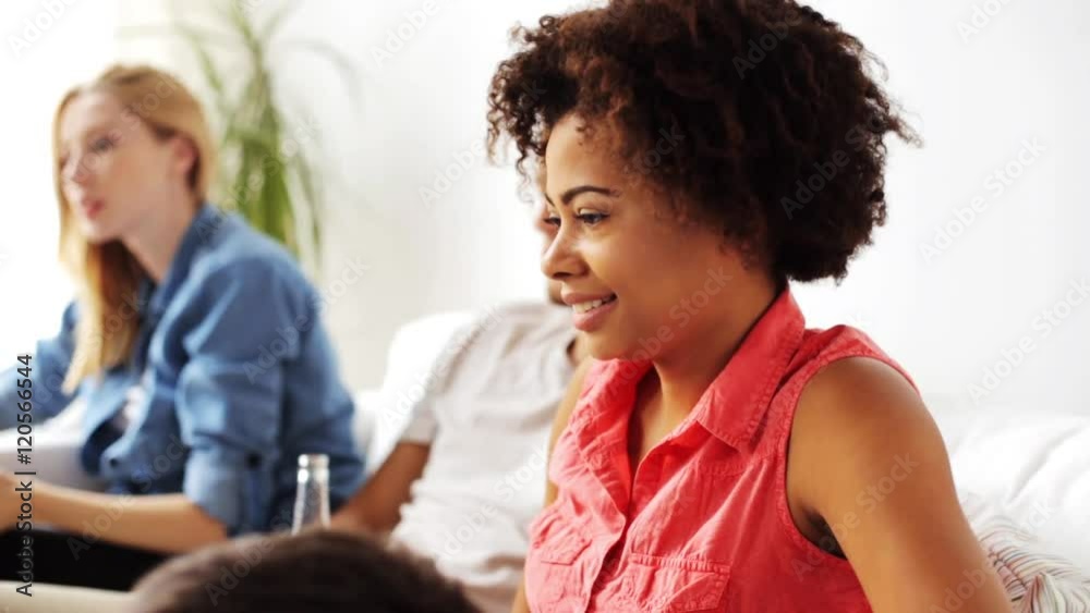 african woman watching tv with friends at home african woman watching tv with friends at home