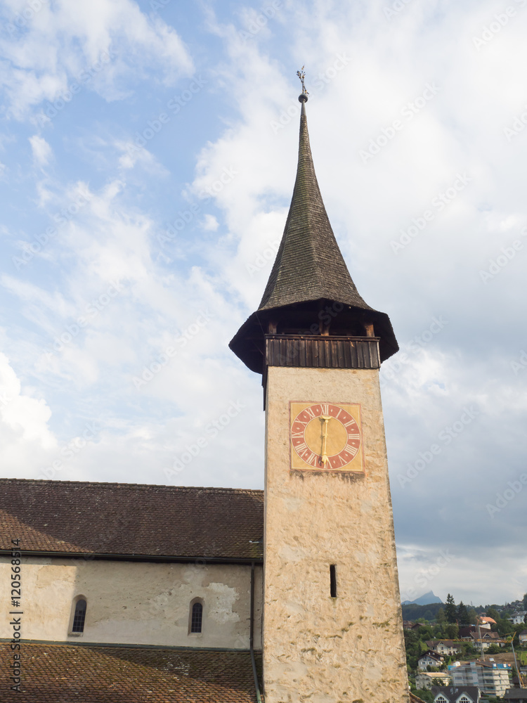 Fototapeta premium Detalle de la torre con reloj puntiaguda de la iglesia del castillo de Spiez en Suiza, viajando en verano de 2016