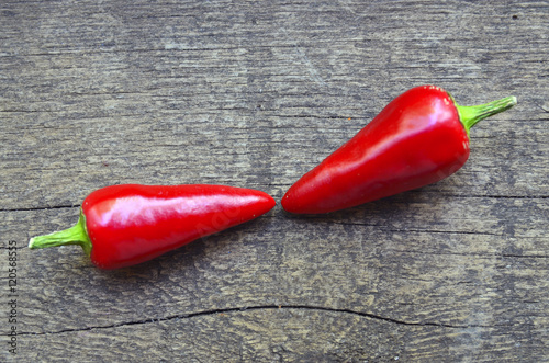 Two red chili peppers on old wooden background.Selective focus.Copy space. photo