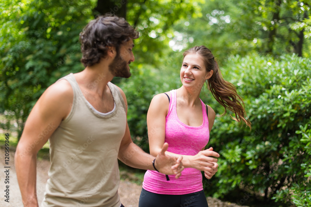 Fototapeta premium Smiling happy couple running in a park