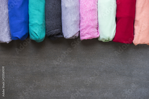 close up of rolled colorful clothes on black background