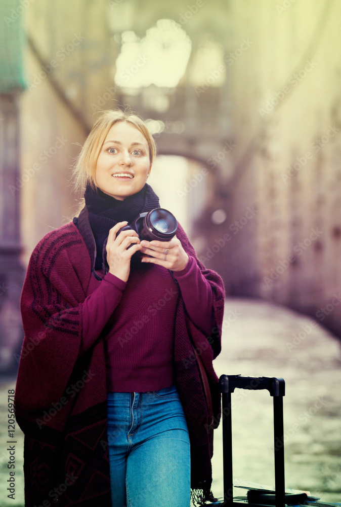 Fototapeta premium Young woman looking and taking pictures outdoors
