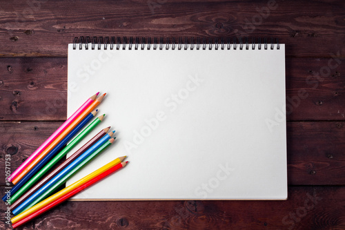  blank paper and colorful pencils on old wooden table with copy