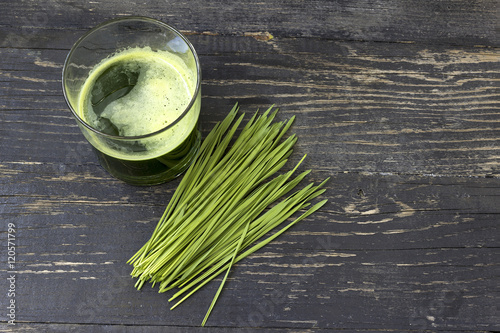 Wheat grass juice on dark wood background