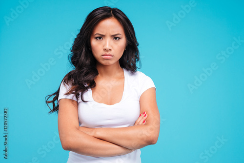 Angry pretty asian woman standing with arms crossed