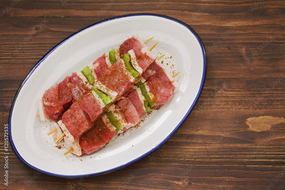 raw meat with pepper for grill on white dish on wooden background raw meat with pepper for grill on white dish on wooden background