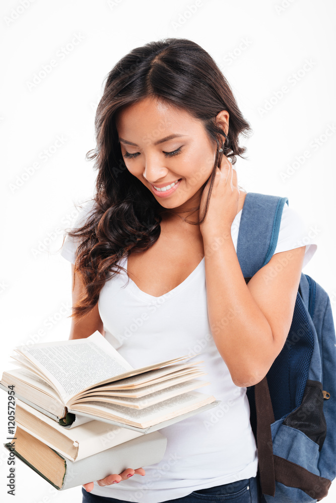 Smiling happy vietnamese girl with backpack reading book Smiling happy vietnamese girl with backpack reading book