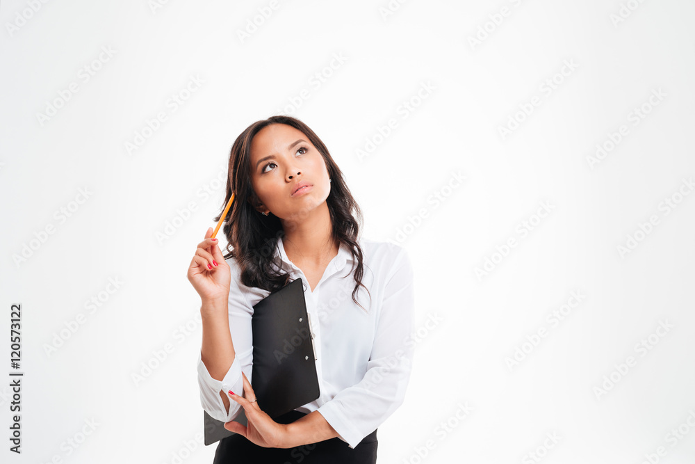 Beautiful pensive asian businesswoman holding clipboard and thinking about something