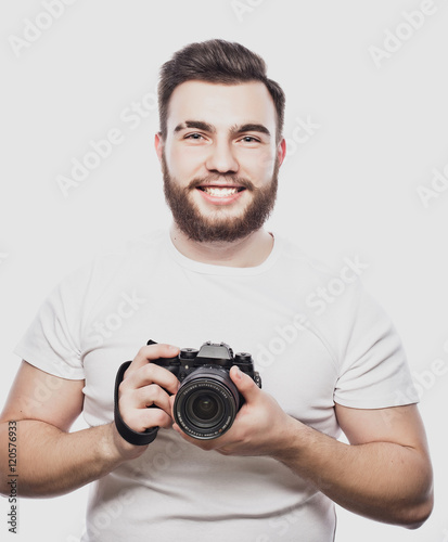 young bearded photographer taking pictures with digital camera.