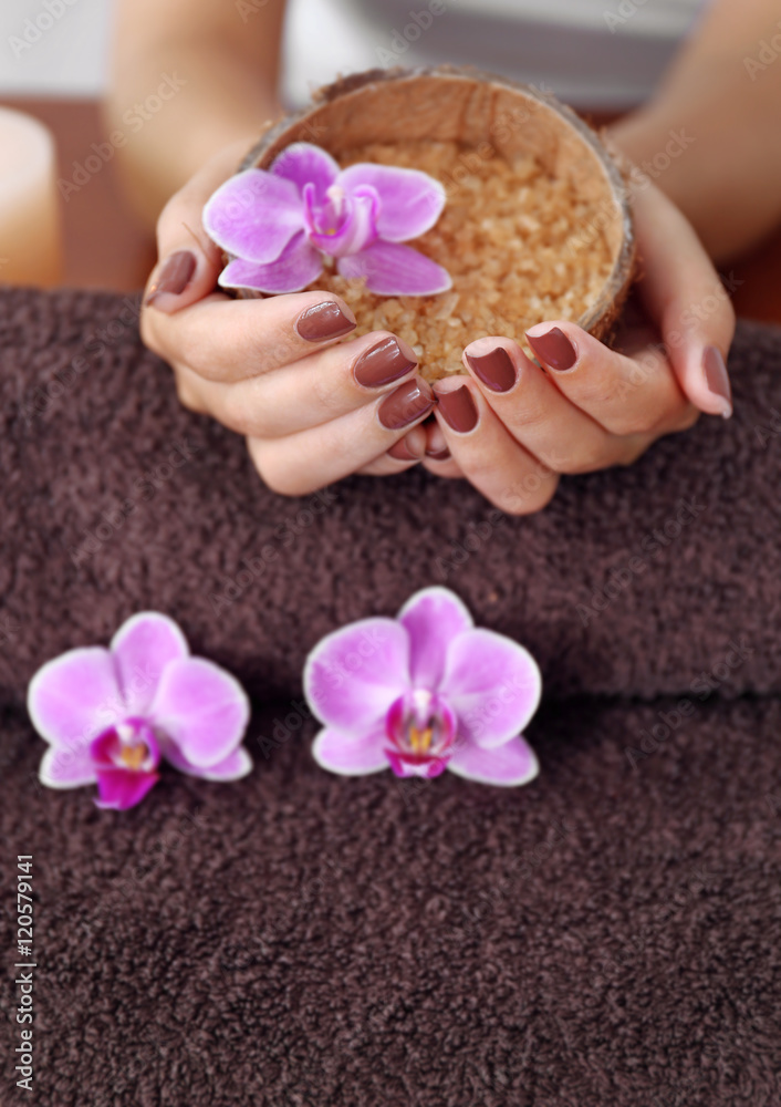 Female hands with brown manicure holding sea salt in bowl, closeup Female hands with brown manicure holding sea salt in bowl, closeup