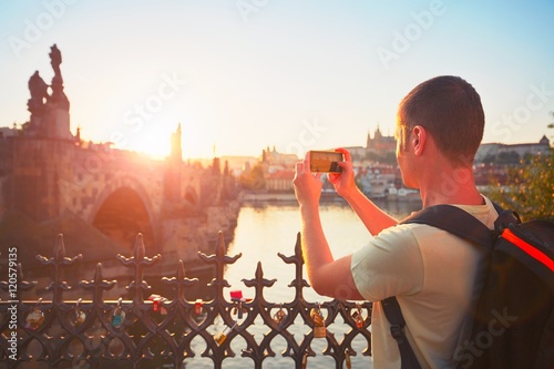 Canvas Print Traveler taking photo by mobile phone