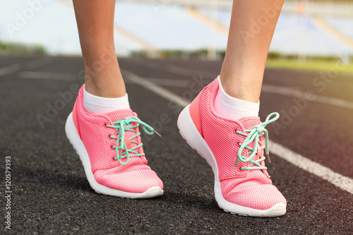 Fototapeta Naklejka Na Ścianę i Meble -  Woman wearing pink sneakers on a running stadium
