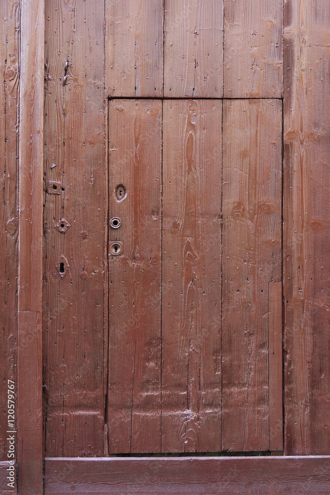 Fototapeta premium small brown wooden door cut out of much larger one