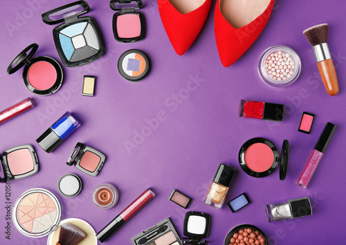 Makeup products, brushes and female shoes on a purple background