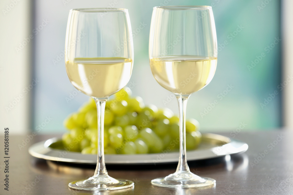 Glasses with white wine and grape on a table Glasses with white wine and grape on a table