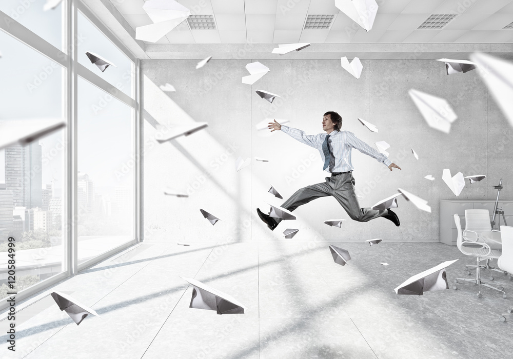Jumping businessman in office . Mixed media Jumping businessman in office . Mixed media