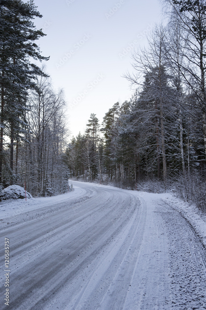 Slippery winter road on a cloudy winter day. Image taken after first snow has arrived in Finland. Slippery winter road on a cloudy winter day. Image taken after first snow has arrived in Finland.