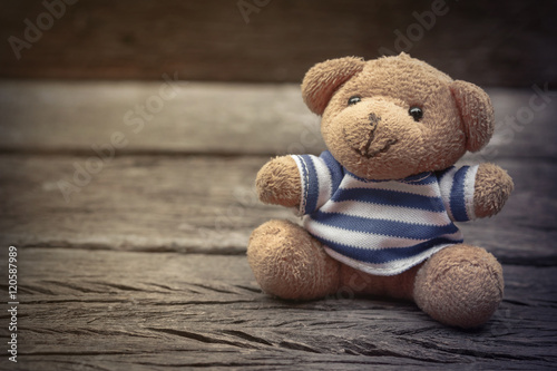 Teddy bears sitting on a wooden floor in the atmosphere lonely, vintage filters © tapui