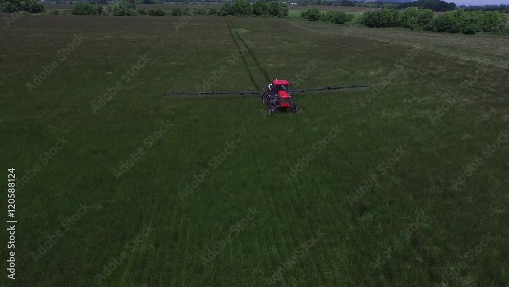 Aerial shot of tractor spraying grass seed farm Aerial shot of tractor spraying grass seed farm