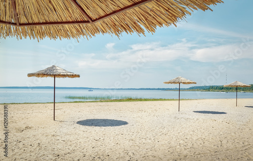Fototapeta Naklejka Na Ścianę i Meble -  .Sunshades on the beach at the lake.Focus concept.