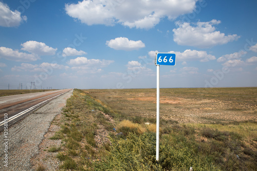 three sixes kilometer mark on summer road and cloudy sky background