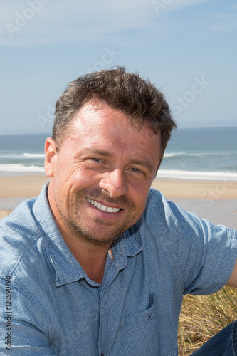 Handsome man at the beach looking at the camera