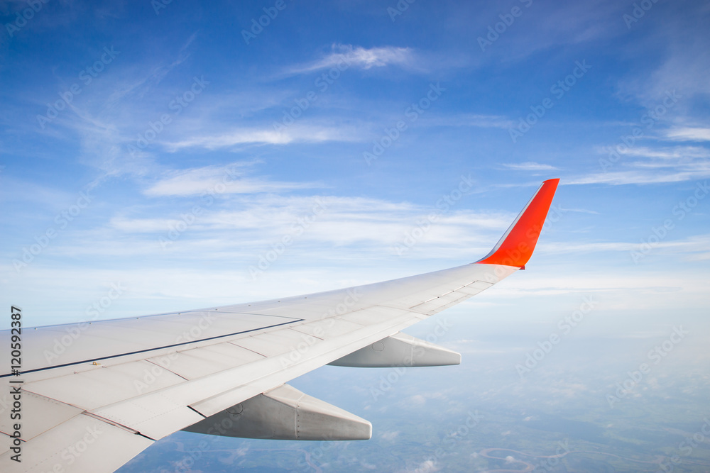 Obraz premium Wing of a plane and blue sky with cloud
