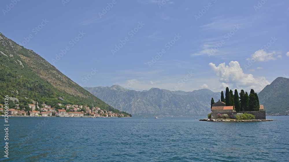 The tiny St George's Island in Kotor Bay, Montenegro, known as the Island of the Dead, with a 12th century Benedictine abbey & cemetery. Perast can be seen on the coast in the background

