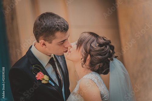 beautiful couple in wedding dress outdoors near the castle columns and old wood doors.