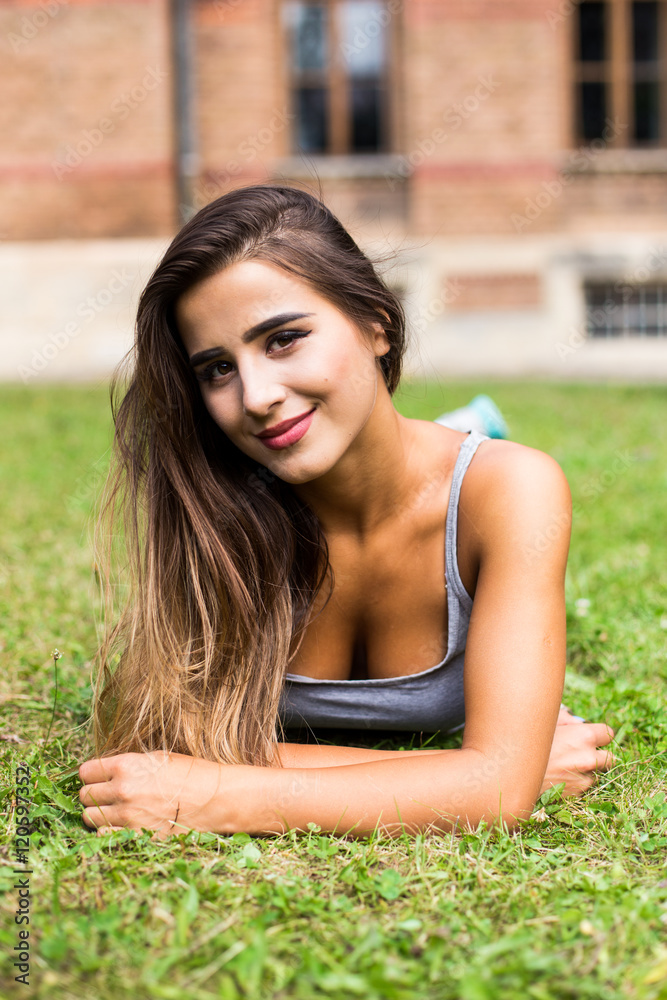 Beautiful woman relaxing at the park lying on grass Beautiful woman relaxing at the park lying on grass