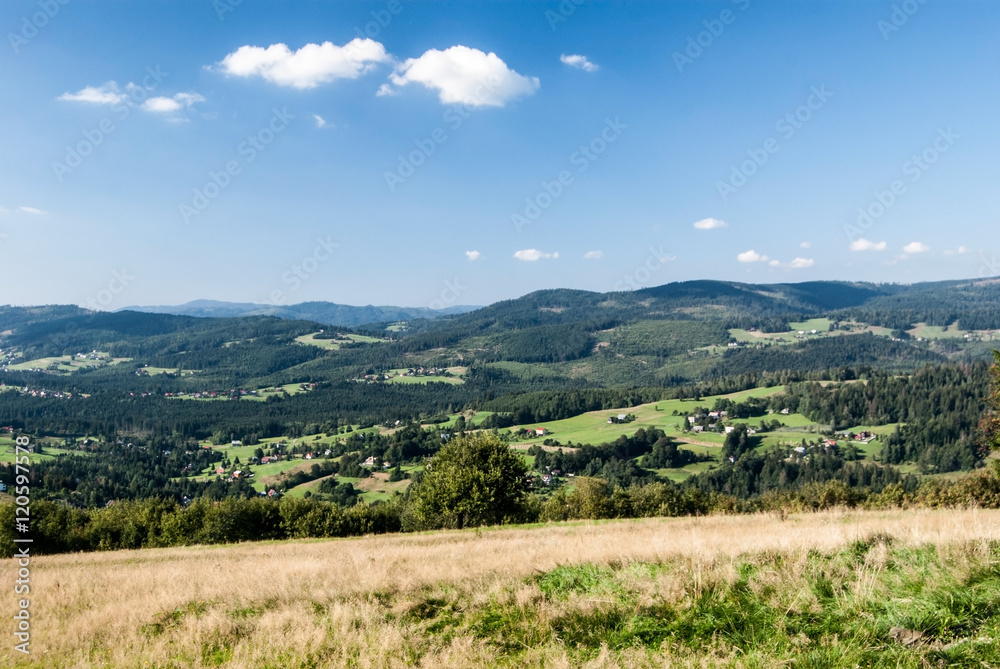 spectacular view with meadows, villages, fields, hills and blue sky with only few clouds from Ochodzita hill near Koniakow village in Beskid Slaski mountains in Poland