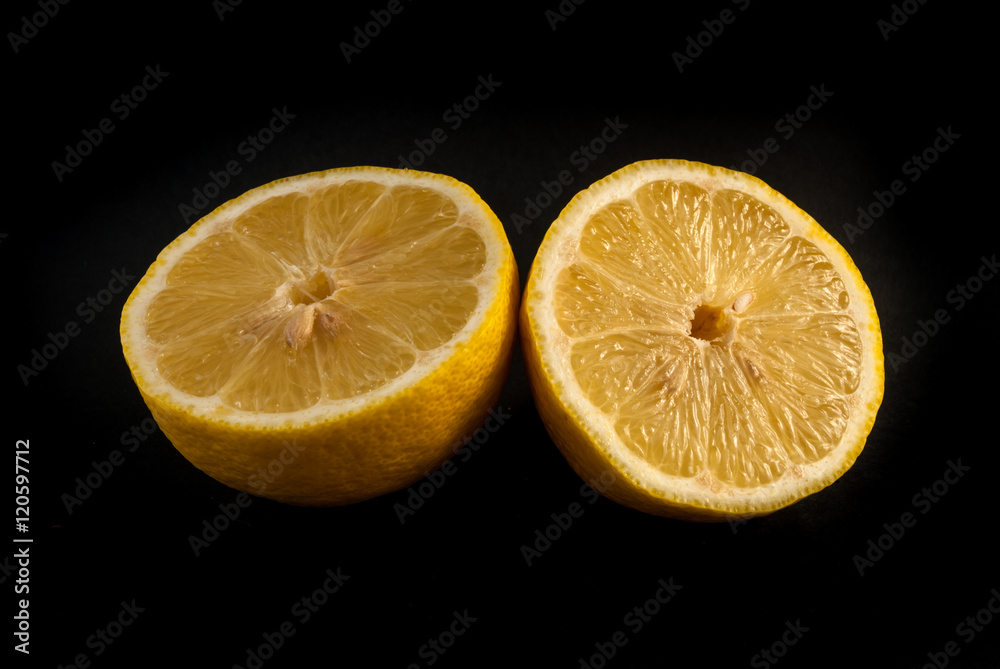 Lemon cut in half on black background Lemon cut in half on black background