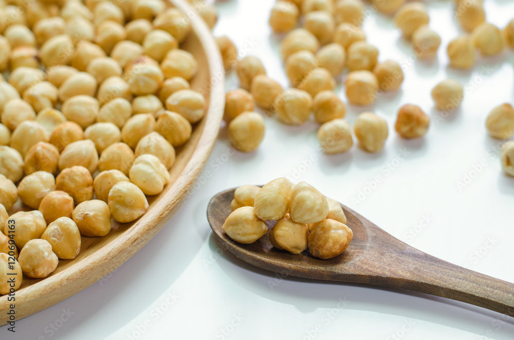 Hazelnuts in spoon and plate wooden on white background Hazelnuts in spoon and plate wooden on white background