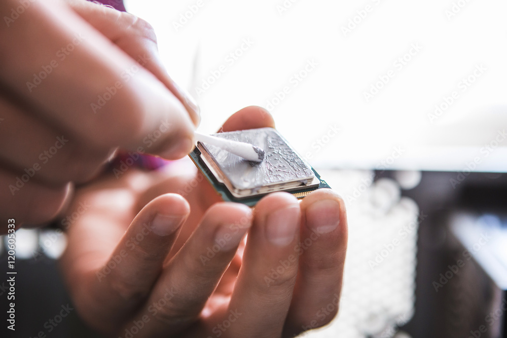 Computer literacy repair men hands, man examines laptop clean and application of new thermal paste.
