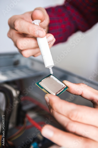 Computer literacy repair men hands, man examines laptop clean and application of new thermal paste.