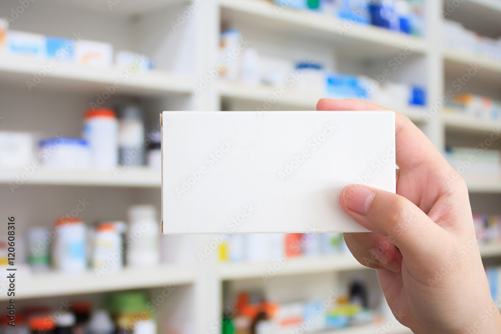 hand hold medicine package over pharmacy hand hold medicine package over pharmacy