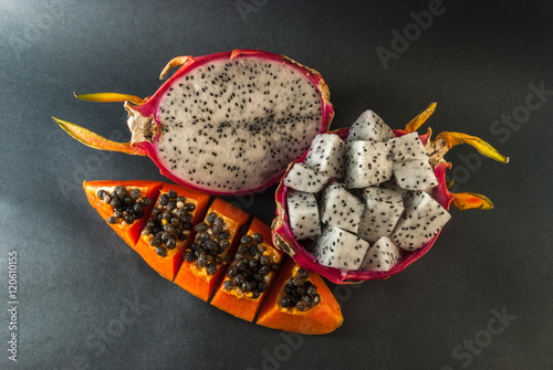 papaya and dragon fruit served for a dessert on black background
