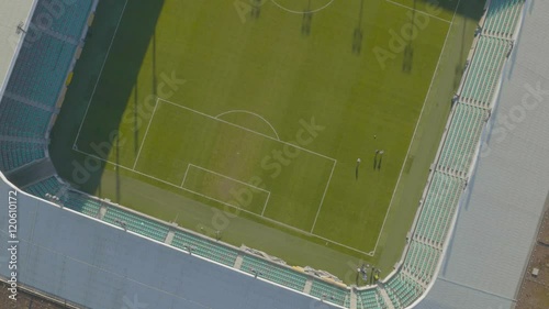 Aerial, Zoom out over boys how play soccer at football stadium
