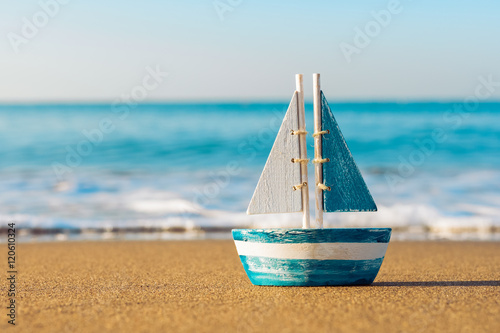 Canvas Print toy sailboat at the seashore