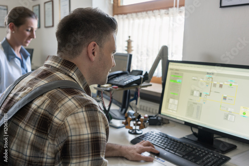 Man and woman in control room of water purification plant monitoring the technical processes