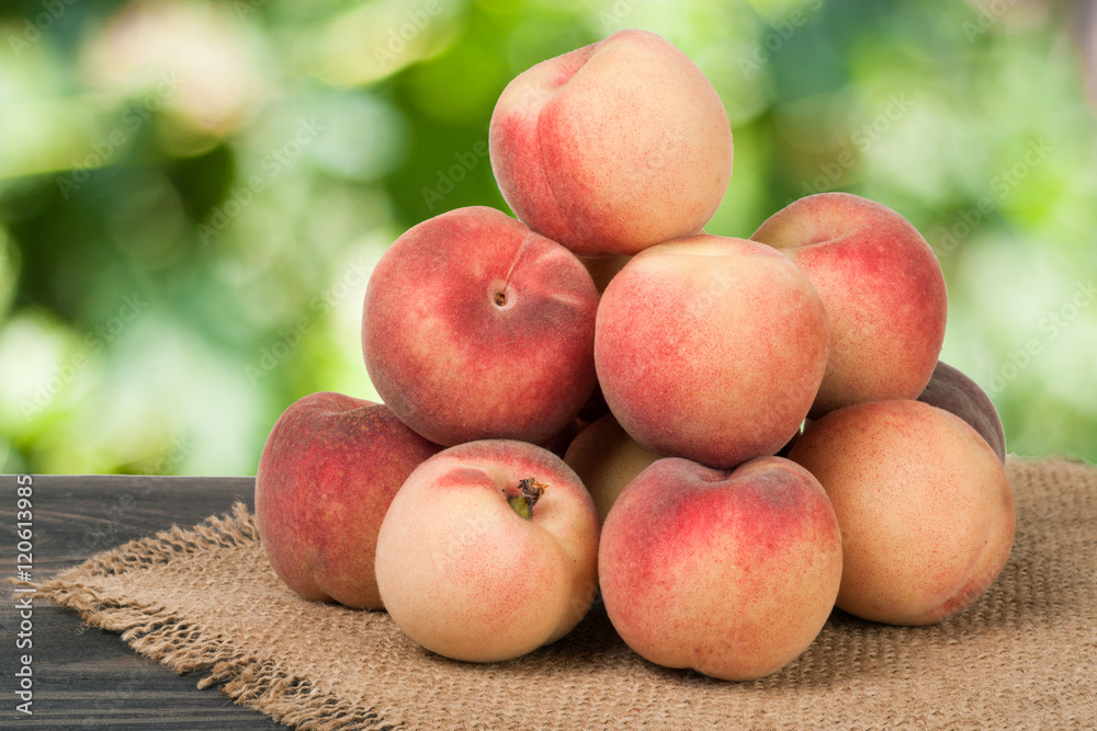 heap of peaches on a wooden table with blurred background heap of peaches on a wooden table with blurred background